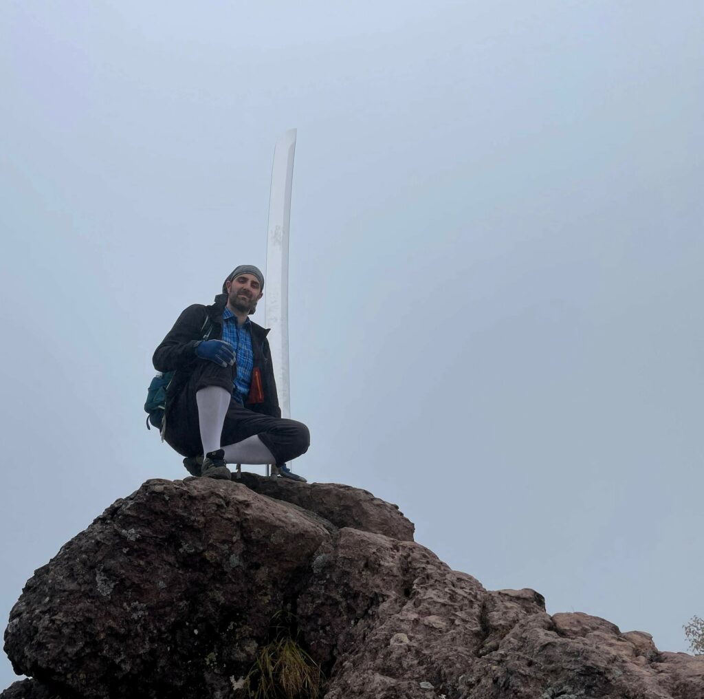 Amb la katana que representa la deïtat Futsunushi no Kami, simbolitzant la força per completar l'ascens